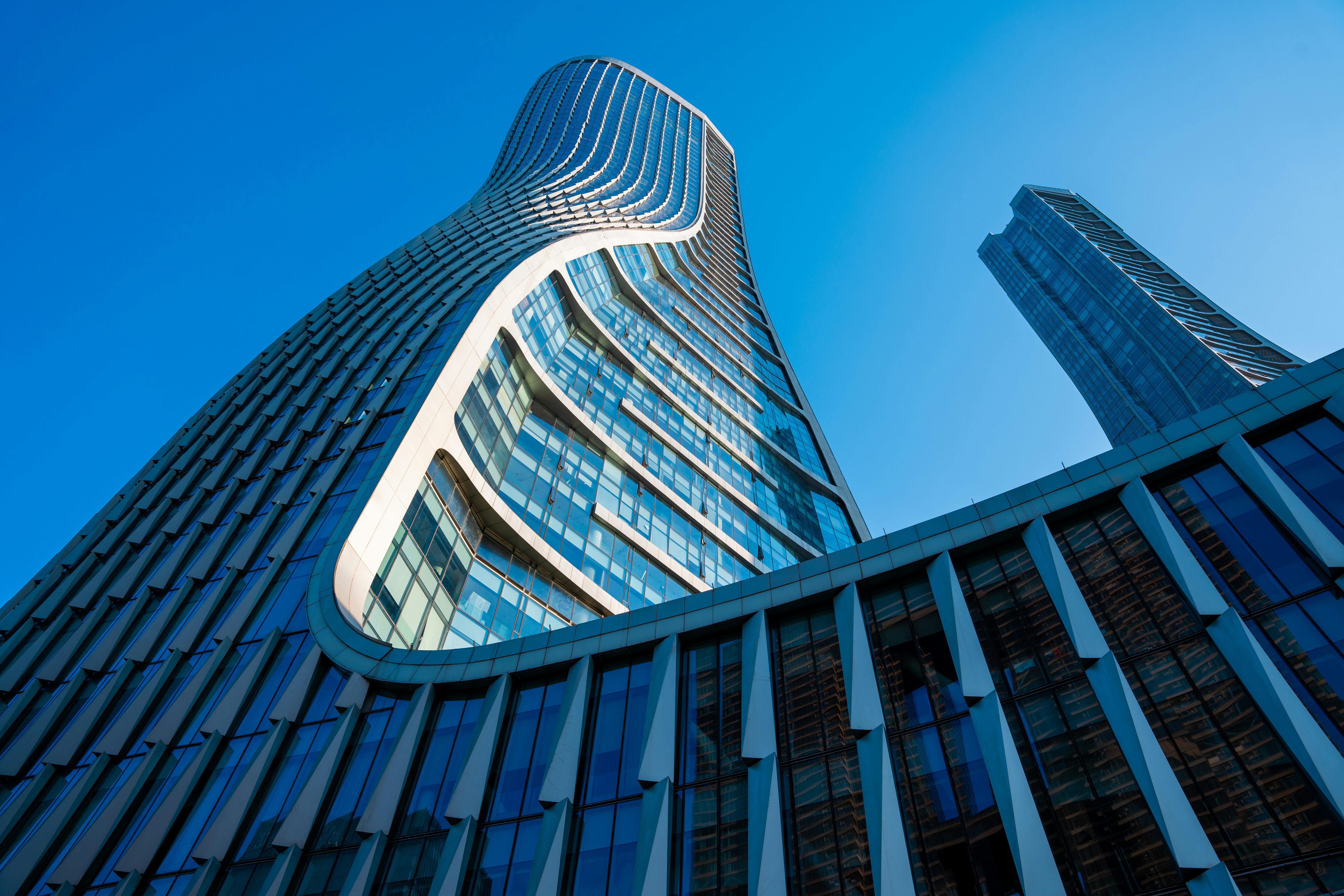 Modernes Bürogebäude der Immobilienagentur mit großen Glasfenstern und grünem Eingang